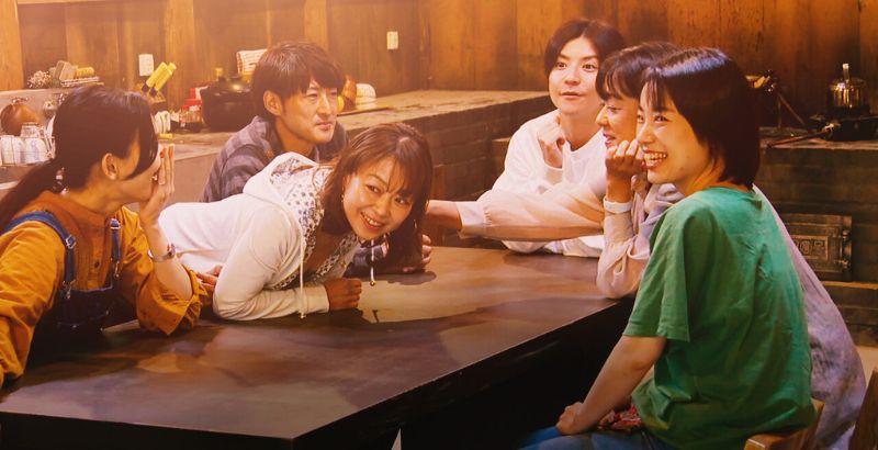the cast sitting at a table together after a conversation